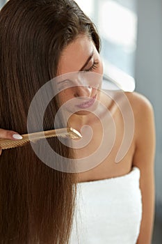 Woman With Haircomb In Hand Hairbrushing. Hair Health