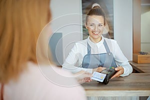 woman hairdresser accepting credit card payments via terminal
