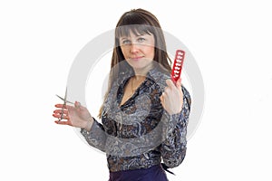 Woman hairdresser with a comb and scissors in hands looking at the camera