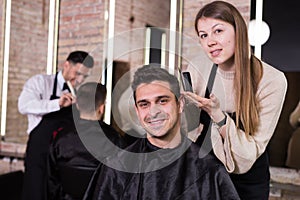 Woman hairdresser discussing hairstyling with male client