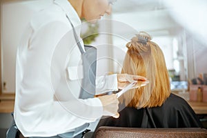woman hairdresser in hair studio cutting hair