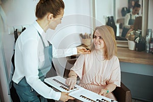 woman hairdresser in modern beauty studio with hair color chart