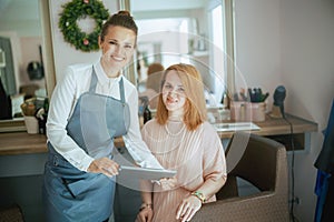 woman hairdresser in modern beauty studio with tablet PC