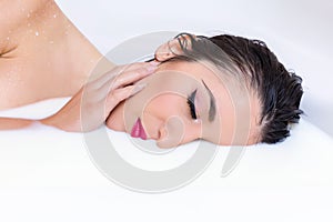 Woman half face in milk bath