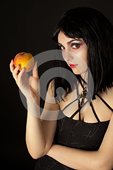 Woman with halloweeen make up holding peach photo