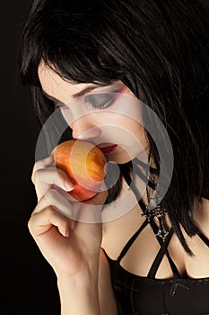 Woman with halloweeen make up smelling peach photo