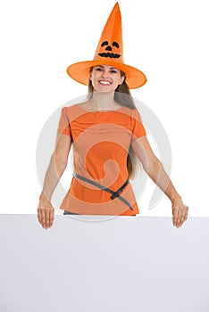 Woman in Halloween hat holding blank billboard