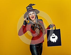 Woman with Halloween shopping bag speaking on a mobile phone