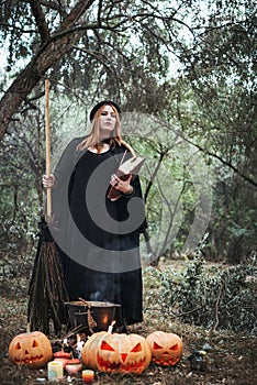 Woman in halloween witch costume in forest