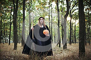 Woman in halloween witch costume in forest