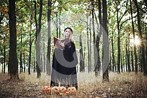 Woman in halloween witch costume in forest