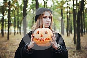 Woman in halloween witch costume in forest