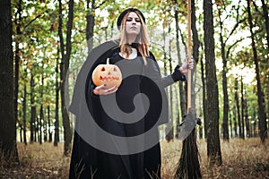 Woman in halloween witch costume in forest