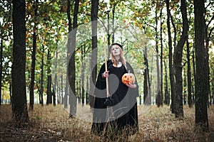 Woman in halloween witch costume in forest