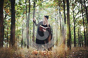 Woman in halloween witch costume in forest