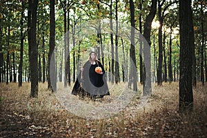 Woman in halloween witch costume in forest