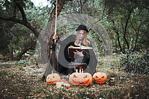 Woman in halloween witch costume in forest