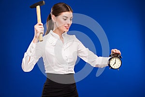 Woman with hammer and alarm clock