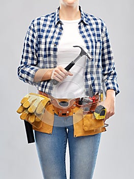 Woman with hammer and working tools on belt