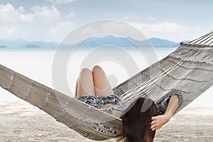 Woman in a hammock on a tropical beach in summer vacation.