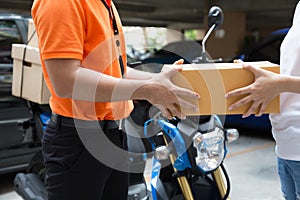 Woman hand accepting a delivery of boxes from deliveryman, Deliver goods by motorcycle service,