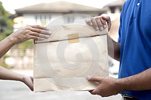 Woman hand accepting a delivery of paper containers for takeaway food from deliveryman