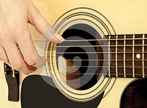 Woman hand on an acoustic guitar photo
