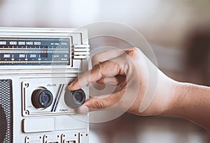 Woman hand adjusting the sound volume on retro radio cassette