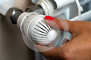 Woman Hand Adjusting The Temperature By Thermostat