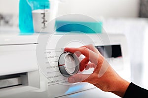 Woman hand adjusting washing machine