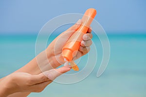 Woman hand apply sunscreen / sunblock on the beach photo