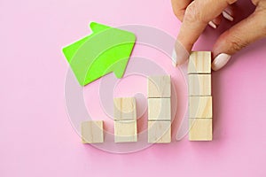 Woman hand arranging empty wood block and copy space on pink background