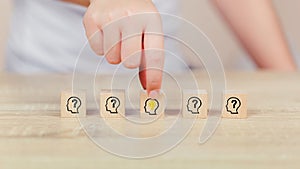 Woman hand arranging wood block with icon head human symbol and light bulb,concept creative idea and innovation