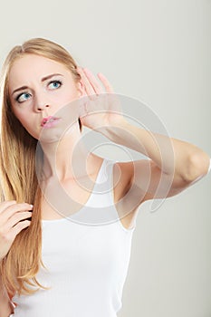 Woman with hand behind ear spying