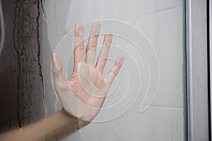 Woman hand behind glass 1