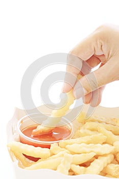 Woman hand being dipped in ketchup.