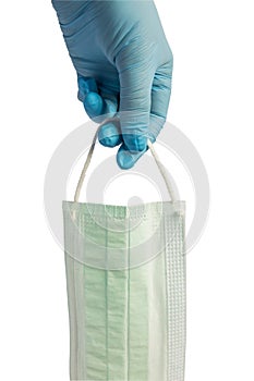 Woman hand in blue latexmedical glove holding medicine protective mask. Isolated on white background. Concept of health care end