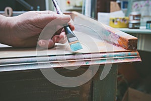 Woman hand with brush paint wooden desk with chalky paint