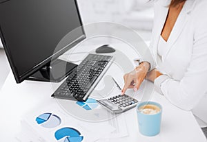 Woman hand with calculator and papers