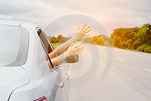 Woman hand in the car relaxing and happy traveler on the road