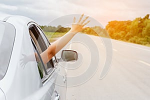 Woman hand in the car relaxing and happy traveler on the road
