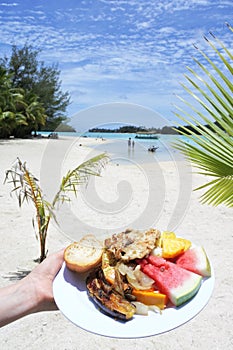 Woman hand carry traditional tropical food in Muri lagoon Rarotonga Cook Islands