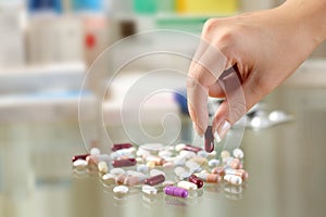 Woman hand catching a pill from a group