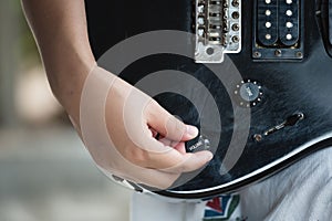Woman hand changing electric guitar settings. Tuning a timbre regulator photo
