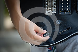 Woman hand changing electric guitar settings. Tuning a timbre regulator photo