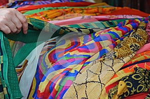 Woman hand choosing colorul scarfs at indian market