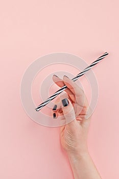 Woman hand with cocktail drinking straw