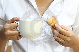 A woman hand a coffee and a croissant