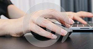 Woman hand with computer mouse, extra close up. Female fingers typing typing on laptop keyboard  and mouse at office. Business con