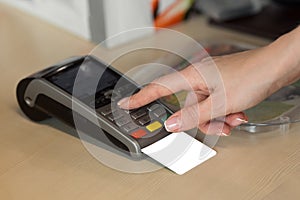 Woman hand with credit card swipe through terminal for sale in restaurant